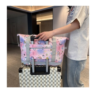Detail of travel tote bag with trolley sleeve and cute unicorn pattern for suitcases