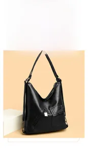 Detail of black pebbled leather hobo bag with silver zipper and rivet pocket accents