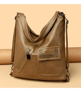 Detail of soft brown PU leather tote bag with rivet flap pocket and zipper accents