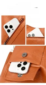 Detail of orange lychee leather bag showing multi-pocket system and metal zippers