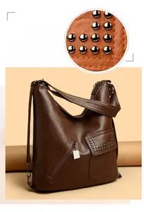 Detail of dark brown leather hobo bag featuring silver rivets and zipper textures