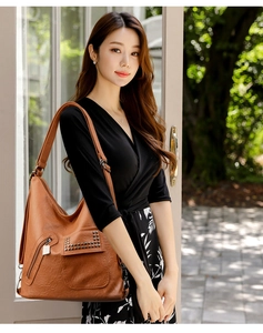 Close-up of vintage brown leather tote bag with silver studs and pocket detail