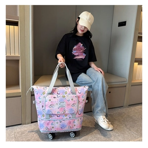 Detail of expandable pastel travel bag with rolling wheels and cute cloud patterns