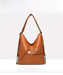 Close-up of yellow-brown leather tote bag with lychee texture and rivet flap detail