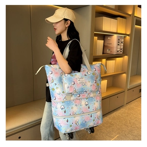 Detail of expandable quilted travel tote bag with cartoon prints and bottom wheels
