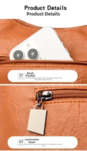 Detail view of the brown leather tote bag showing a back zipper pocket and metal puller