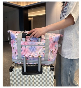 Detail of pink gradient unicorn travel bag with trolley sleeve secured to a suitcase