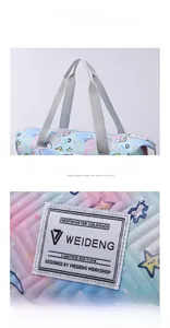 Detail of ergonomic nylon handles and quilted rainbow fabric on large travel tote bag