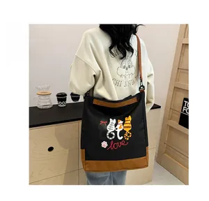 Close-up of a canvas tote bag with cute cat illustrations and brown leather patchwork