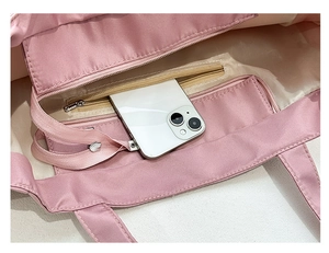 Internal view of pink tote bag showing large main compartment and zipper pocket