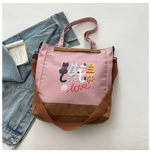 Detail of pink canvas tote bag with cartoon cat prints and adjustable shoulder strap
