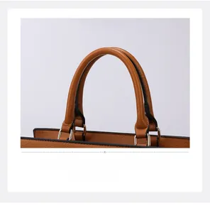 Detail of brown litchi pattern leather handle with sturdy metal ring attachment