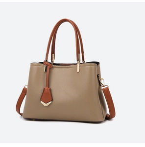 Detail of khaki pebbled leather handbag with brown handles and gold hardware
