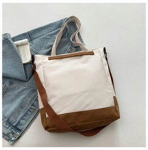 Detail of a beige and brown large nylon tote bag with adjustable shoulder straps