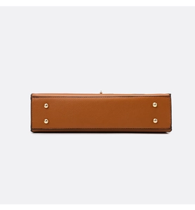 Detail view of the caramel leather tote bottom with four golden metal protective feet