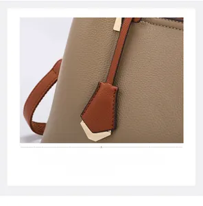 Detail of lychee pattern leather tote with golden hardware and orange-brown trim
