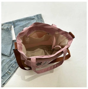 Detail of pink cartoon cat tote bag showing spacious interior with zipper pocket