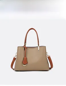 Detail of khaki pebbled leather tote bag with brown handles and gold hardware accents