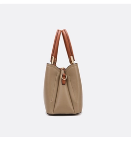 Close-up of khaki and brown lychee textured leather handbag with gold zipper detail