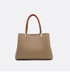 Detailed view of pebbled leather texture on an elegant brown tote bag with gold accents