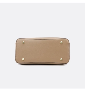 Detail view of khaki tote bag base featuring four protective gold metal feet and pebble leather