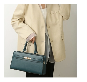 Detail of dark green lychee pattern leather tote with gold buckle and buckle clasp