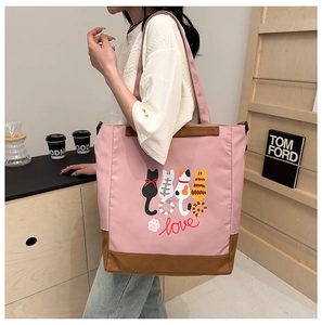 Detail of pink canvas tote bag with cute cat prints and reinforced brown handles