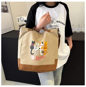 Close-up of khaki tote bag featuring four cartoon cats and love script illustration