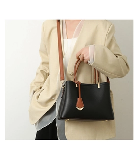 Detail of minimalist black and brown tote bag showing lychee grain leather and texture