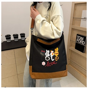 Detail of canvas tote bag with cute cat prints and adjustable brown shoulder strap