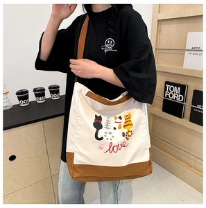 Close-up of printed canvas tote bag featuring cute cartoon cats and love inscription