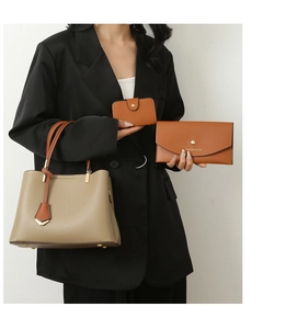 Detail view of khaki tote bag with orange wallet and card holder accessory set