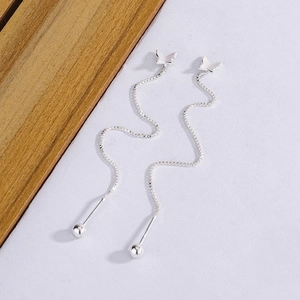 Detail view of long butterfly tassel earrings with silver beads and delicate chains