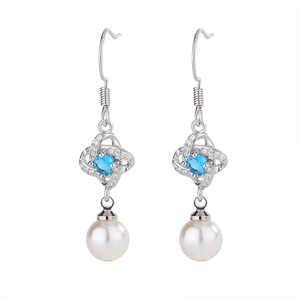 Detail of silver clover earrings featuring blue gemstone accents and round white pearls
