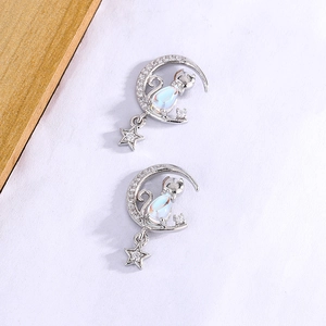 Gros plan de boucles d'oreilles chat avec pierre de lune et oxydes de zirconium