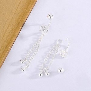 Detail of silver crown navel ring with dangling tassel chains and bead pendants
