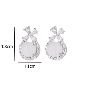 Detailed view of silver bow earrings with white chalcedony and zircons measuring 1.8cm