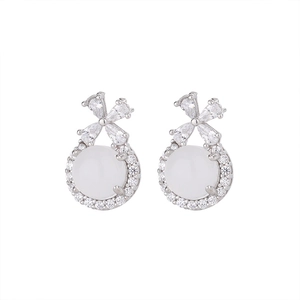 Detail of silver bow earrings with white chalcedony stone and pavé zircon border