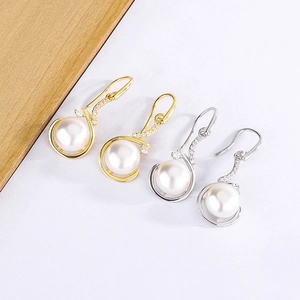 Détails de boucles d'oreilles en perles dorées et argentées avec des cristaux brillants