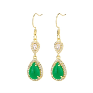 Macro detail of teardrop emerald zircon earrings with gold plating and pear cut stones
