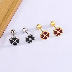 Detail of four-leaf clover ear studs with red and black enamel and beaded edges