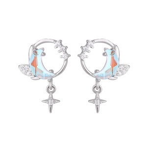 Macro detail of silver moon and star earrings with blue crystals and sparkling zircons