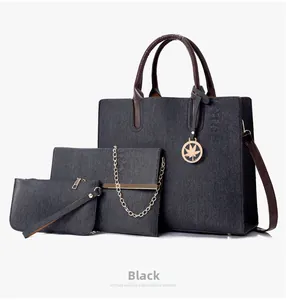 Detailed view of 3-piece tote bag set in black denim fabric with golden maple leaf charms