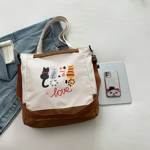 Canvas tote bag with cute cartoon cat prints, dual straps, and a minimalist design
