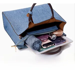 Detailed view of large denim tote bag interior showing spacious storage for tablet and umbrella