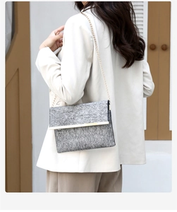 Chic grey tweed chain bag with gold hardware worn by model in minimalist setting