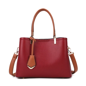Burgundy faux leather tote bag with caramel handles and gold hardware on white background
