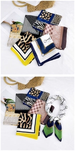 Detail of silk scarves with leopard and paisley prints tied to a woven handbag