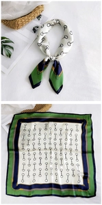 Detail of silk square scarf with classic equestrian horsebit print in green and navy