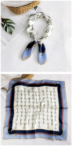 Detail of silk square scarf featuring classic horsebit and chain patterns on ivory fabric